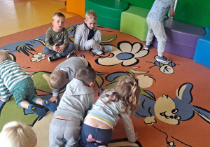 uśmiechnięte dzieci stoją na dywanie
